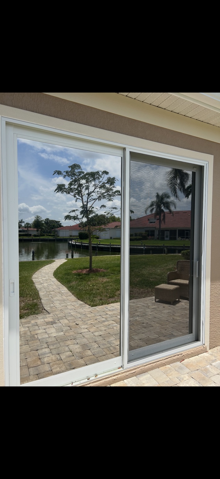 Tinted residential sliding glass door overlooking a canal