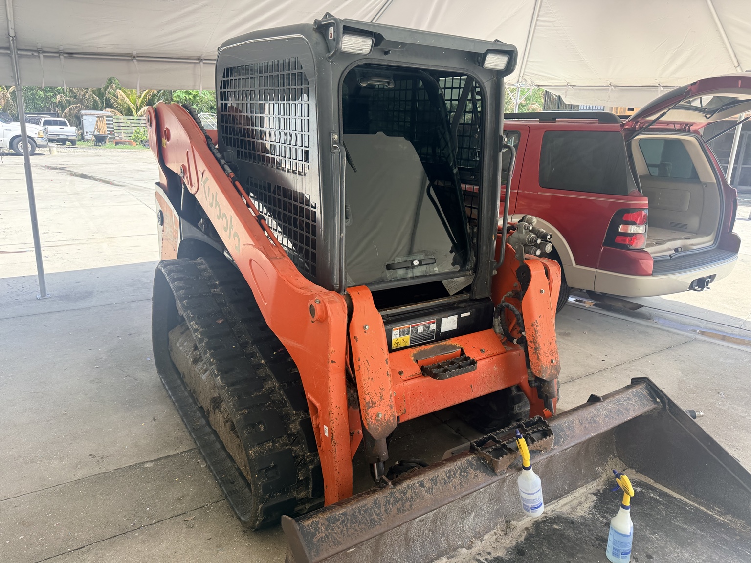 Orange skid steer with professionally tinted side cab glass